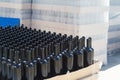 Black wine bottles on pallets in outside storage area