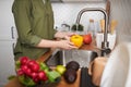 Side view closeup of woman washing vegetables in kitchen Royalty Free Stock Photo