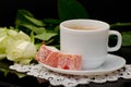 Side view of a coffee cup with milk close-up, oriental sweets. smartphone, white roses on a black background Royalty Free Stock Photo