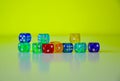 Side view of colourful dices laying in green background