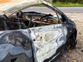 Side view of a completely burned car showing warped and blistered paint, missing interior, and rusted components after Royalty Free Stock Photo