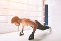 Side view of a concentrated boxer with naked torso doing push ups on boxing ring.