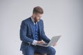 Side view of concentrated businessman in armchair working on laptop Royalty Free Stock Photo