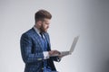 Side view of concentrated businessman in armchair working on laptop.  on grey Royalty Free Stock Photo