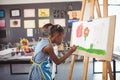 Side view of concentrated girl painting on canvas Royalty Free Stock Photo