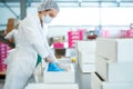 Confectioner at factory putting parchment into box Royalty Free Stock Photo