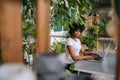 Side view of confident African-American young businesswoman working on laptop computer sitting at desk at home office Royalty Free Stock Photo