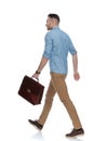 Side view of confident casual holding briefcase, walking Royalty Free Stock Photo
