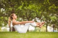 Side view of confident woman exercising while sitting on grass Royalty Free Stock Photo