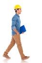 Side view of a construction engineering student walking with cl