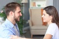 Side view of a couple talking sitting on a couch and looking each other at home Royalty Free Stock Photo