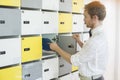 Side view of creative businessman putting files in locker at office Royalty Free Stock Photo