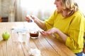 Mature woman with pills and cup of tea