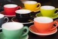 Side view cup of coffee colorful alternating colors is bright Red, Yellow, Orange, Green, Gray, Black and saucer for background in Royalty Free Stock Photo