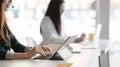 Side view of customer service sitting in line call centre operation and talking on headset in office room Royalty Free Stock Photo