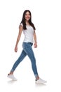 Side view of cute casual womanin jeans walking
