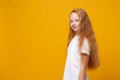 Side view of cute little ginger kid girl 12-13 years old in white t-shirt isolated on yellow wall background children Royalty Free Stock Photo