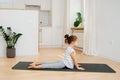 Side view of a cute little girl doing yoga on a mat at home. Upward facing dog Royalty Free Stock Photo