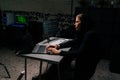 Side view of dangerous hacker man in sweatshirt hacking online web site, engaging hacking into security systems, using