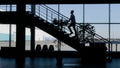 Side view of dark stairs hidden in the shadow with walking people. HDR. Silhouette of stairs decorated by plants in Royalty Free Stock Photo