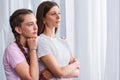 side view of daughter embracing worried mother from behind