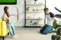 side view of daughter playing with tied father and pretending shooting with toy bow