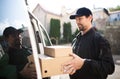 Side view of delivery man courier delivering parcel box in town. Royalty Free Stock Photo