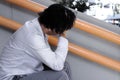 Side view of depressed stressed young Asian business man with hands touching head and feeling disappointed or exhausted with job. Royalty Free Stock Photo