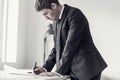 Side view of a designer or draftsman using ruler and pencil while working at the plan Royalty Free Stock Photo