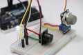 Side view of Different electronic components on a breadboard circuit with microcontroller on the background showing the concept of