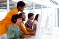 Customer service executive trainer assisting her team at desk Royalty Free Stock Photo