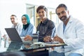 Medical team looking at camera while working together at desk Royalty Free Stock Photo