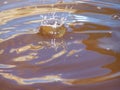 Side view Dome burst crown of water from a water drop impacting a stationary body of water