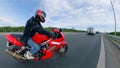 Side view of the driver riding the motorcycle along the highroad. Motorcycle on a road.