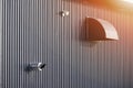 Dryer vent with little megaphone and gas heating boiler flue chimney on grey corrugated metal wall of factory building