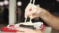 Side view of eating noodles with vegetables with chopsticks. Media. Close up of man eating vegetarian asian dish, wok Royalty Free Stock Photo