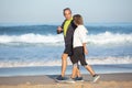 Side view of elderly couple enjoying walk along seashore Royalty Free Stock Photo