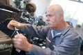 Side view elderly man working at table in garage Royalty Free Stock Photo