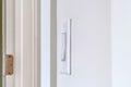 Side view of electrical rocker light switch mounted on white interior wall