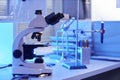 Side view electronic microscope on laboratory workstation in neon light
