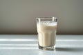 Side view elegance Glass of milk on white table, gray background