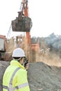 Side view of engineer using walkie-talkie at construction site