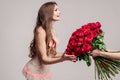 Side view of excited woman getting big bouquet of red roses Royalty Free Stock Photo