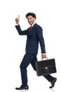 Side view of excited young businessman with bag pointing finger up Royalty Free Stock Photo