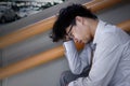 Side view of exhausted stressed young Asian business man feeling tired or disappointed with job. Royalty Free Stock Photo