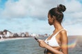 Brazilign female with smartphone on the beach