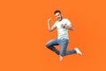 Side view of extremely happy man jumping in air gesturing yes i did it. isolated on orange background