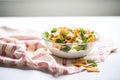 side view of fattoush in a glass bowl on a linen napkin