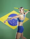 Side view of female athlete throwing javelin against Brazilian flag Royalty Free Stock Photo