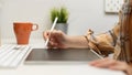 Side view of female graphic designer working with digital tablet on computer table Royalty Free Stock Photo